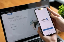 a-woman-holds-apple-iphone-with-linkedin-application-on-the-screen